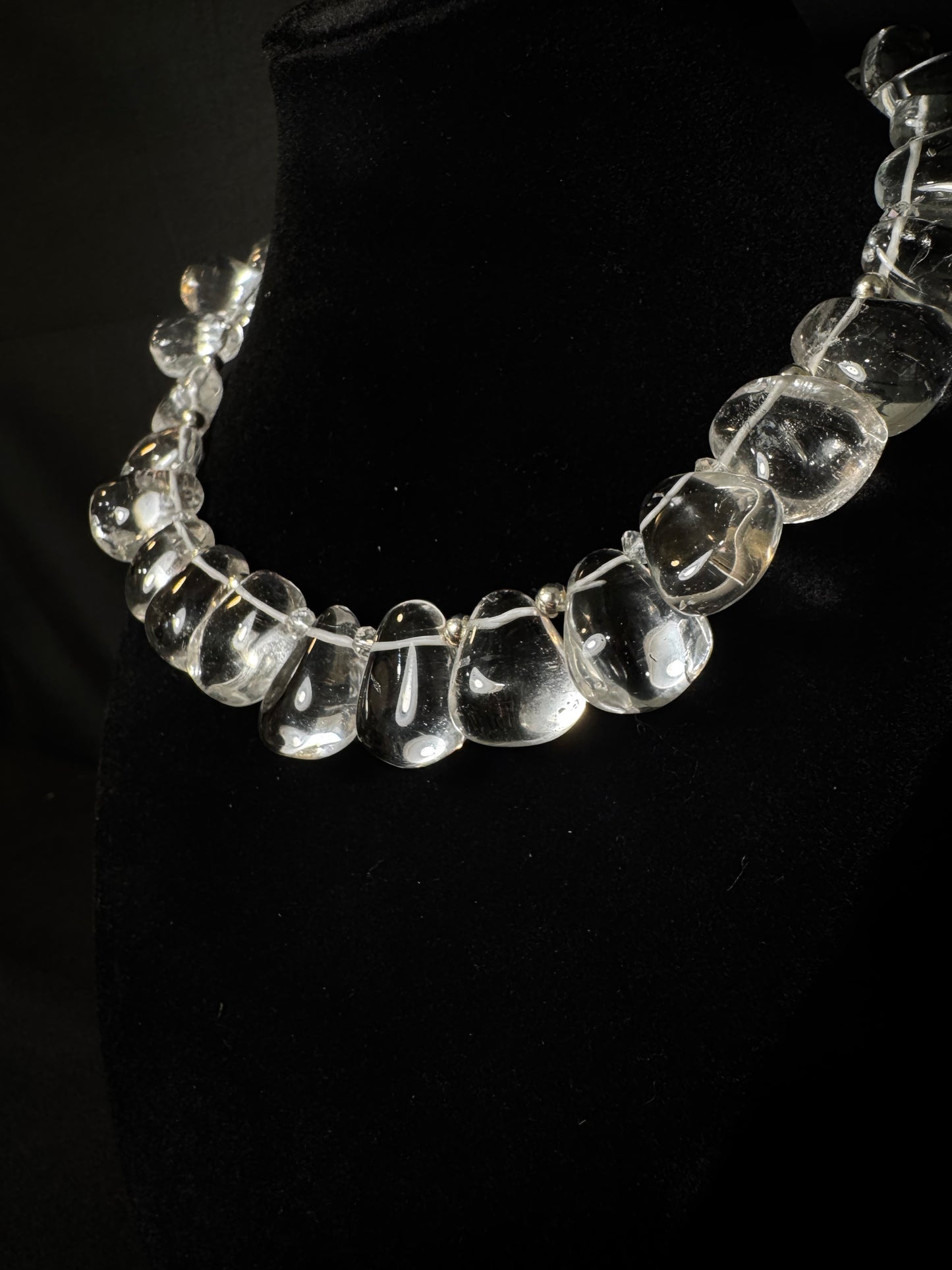 Clear glass beaded necklace on a black background
