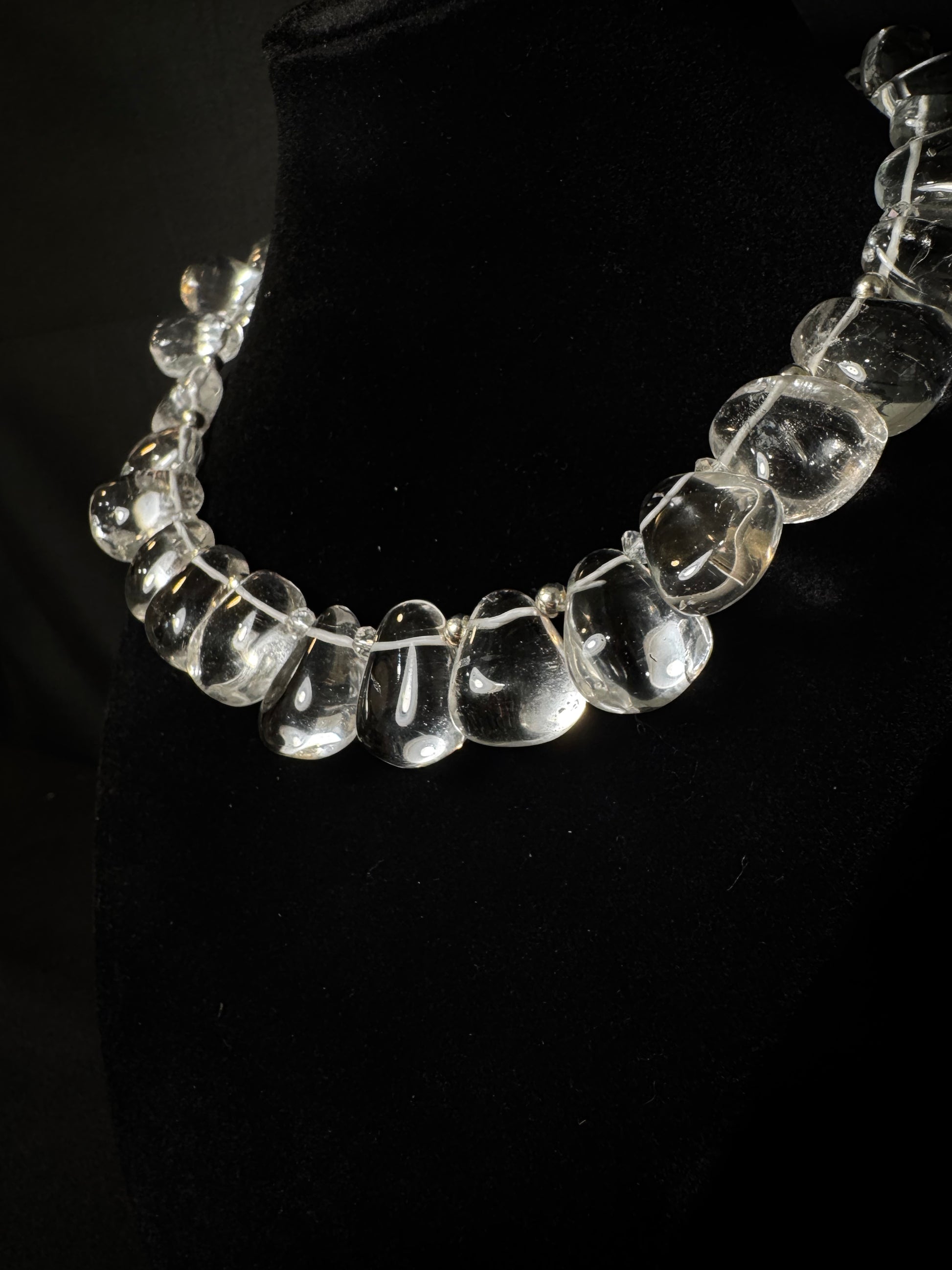Clear glass beaded necklace on a black background