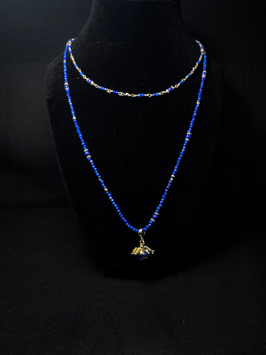 Blue beaded necklace with a pendant on a black mannequin bust