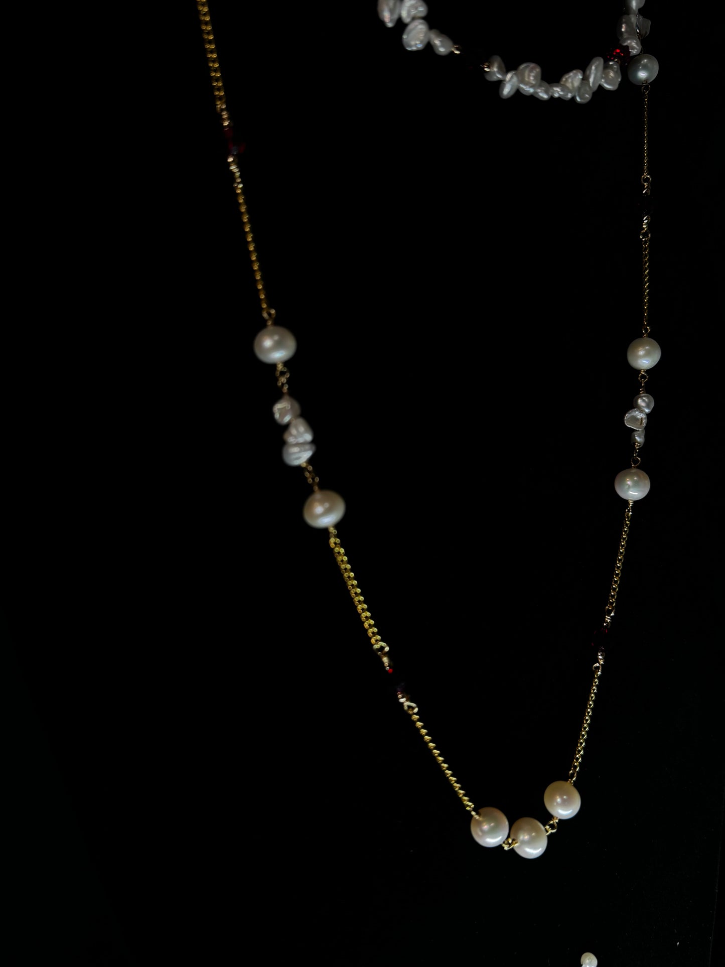 Gold necklace with pearls on a black background