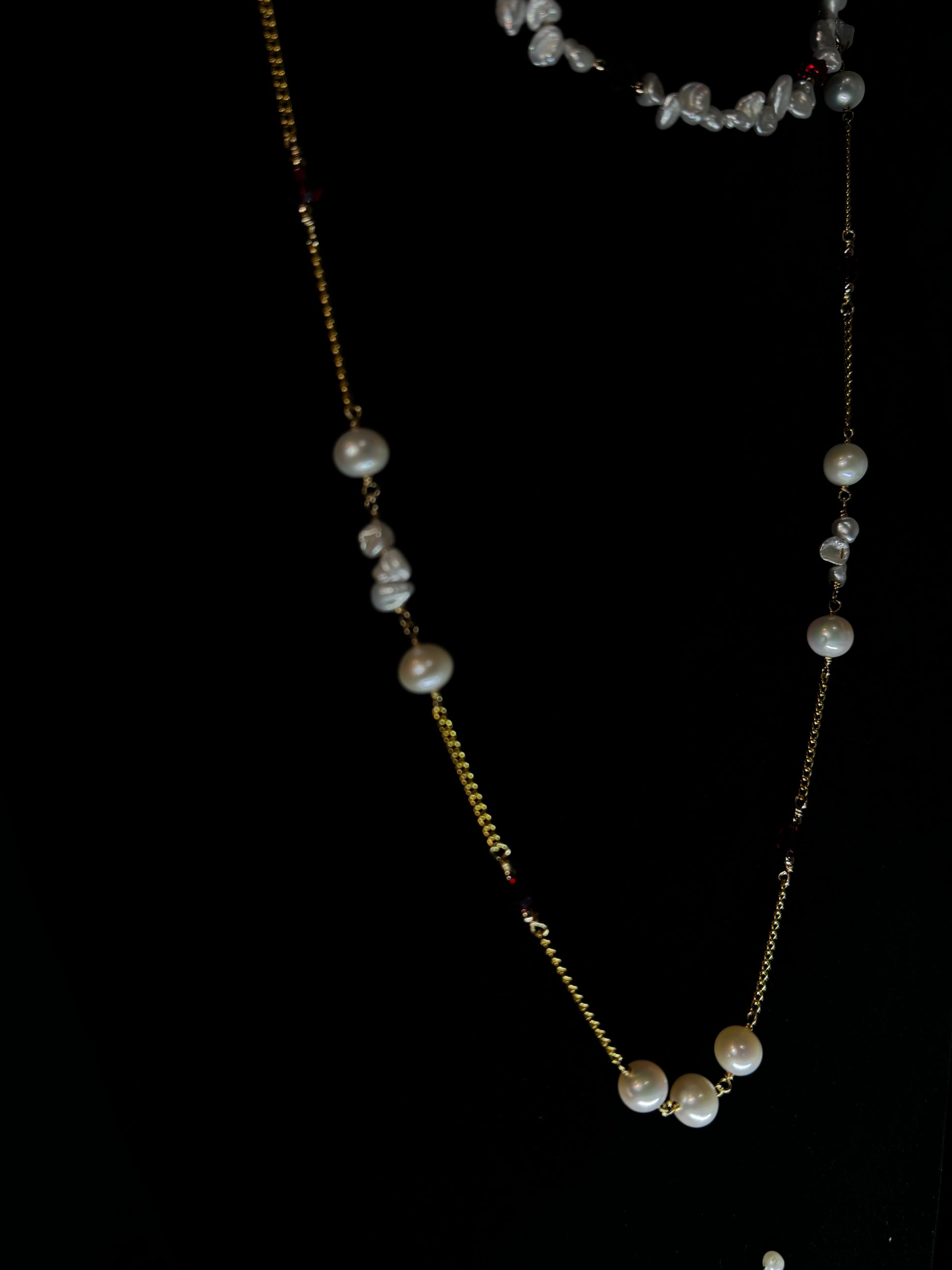 Gold necklace with pearls on a black background